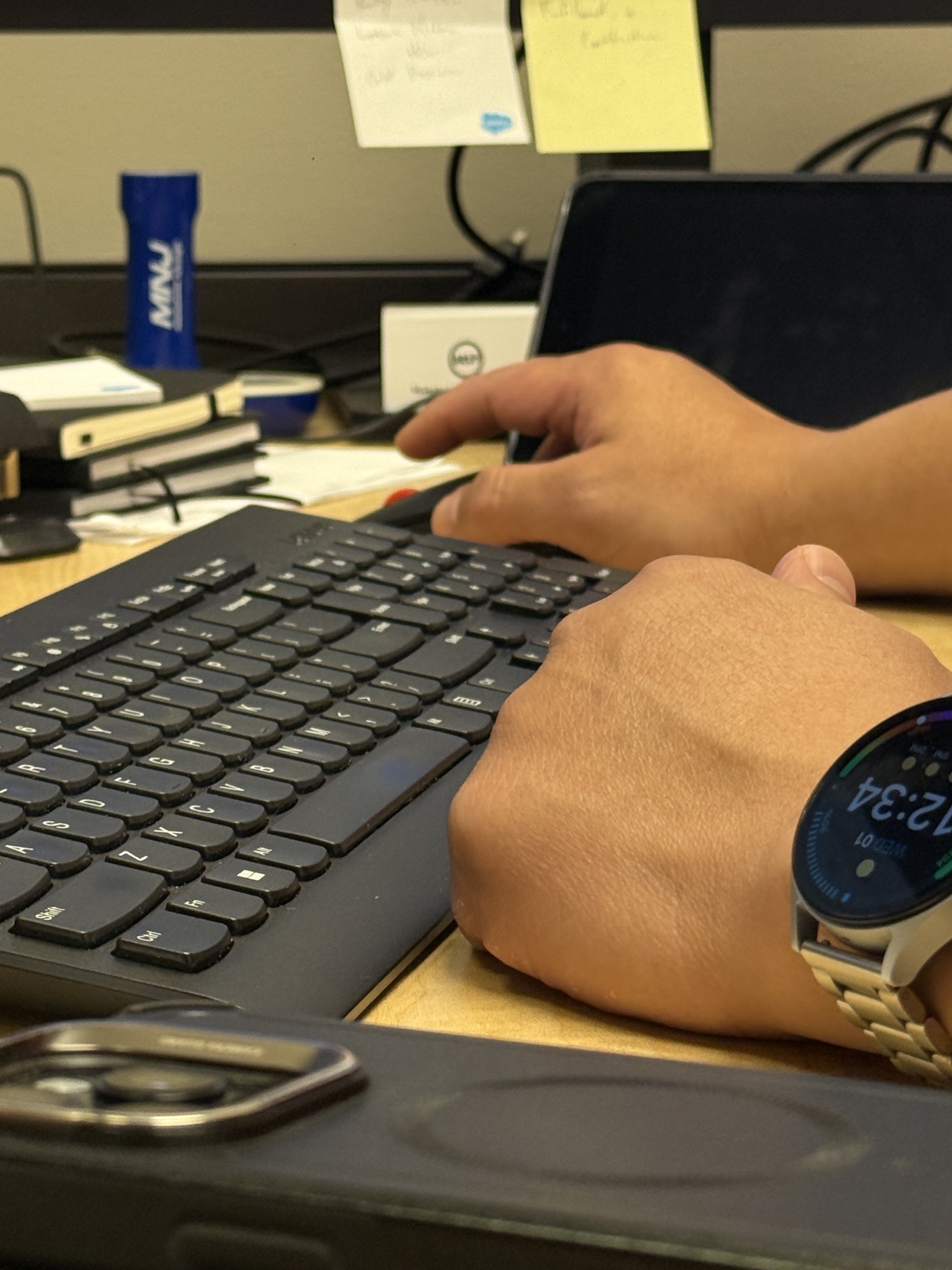 Close view of Joseph Park working at a keyboard and laptop.